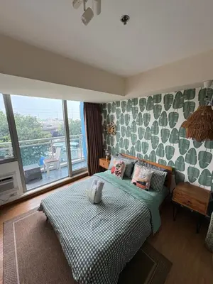a bedroom with a bed and a large window at Affordable Cozy Plage by Martian in Manila
