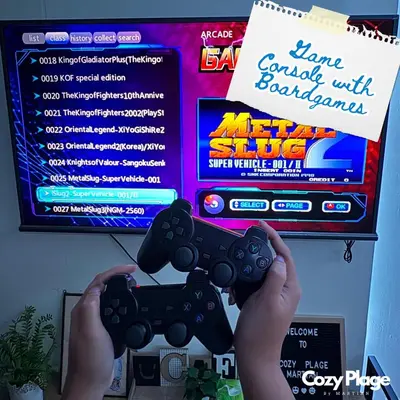 a person holding a video game controller in front of a tv at Affordable Cozy Plage by Martian in Manila