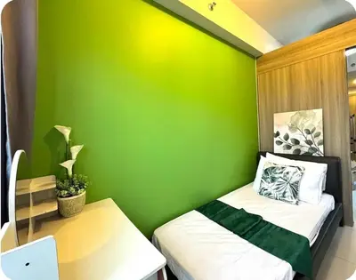 a small green room with a bed and a desk at 2BR Solana Suite 4 at Coast Residences in Manila