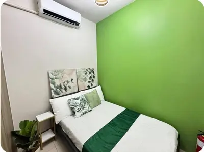 a green room with a bed with a green wall at 2BR Solana Suite 4 at Coast Residences in Manila