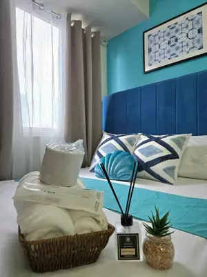 a hotel room with a basket of towels on a bed at 1BR Solana Suite 5 at Coast Residences in Manila