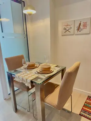 a dining room table and chairs with a glass table and chairs at Azure Urban Resort Residences in Manila