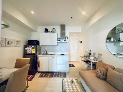 a kitchen and living room with a couch and a table at Azure Urban Resort Residences in Manila