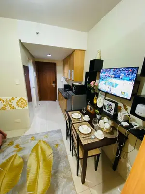 a living room with a table and a kitchen at 333D- 1br 1folding bed pool view in Manila