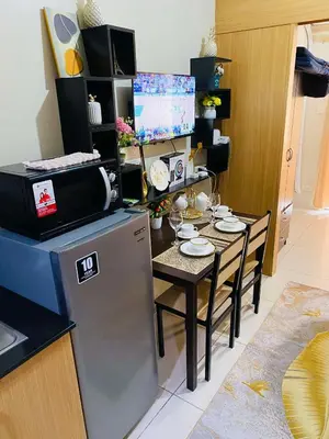 a kitchen with a small table and a refrigerator at 333D- 1br 1folding bed pool view in Manila