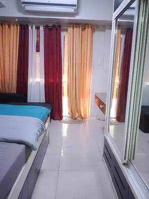a bedroom with a bed and a window with curtains at 257 moa view with balcony bigcut in Manila