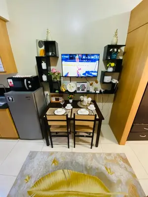 a living room with a table and a television at triple-D in Manila