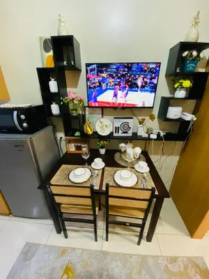 a small living room with a table and a tv at triple-D in Manila
