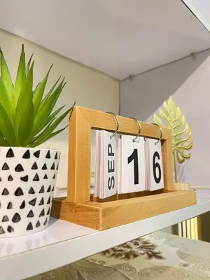 a shelf with a clock on it with a plant at Orchids Shore Residences Direct Pool Access in Manila