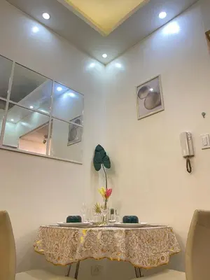 a dining room table with a vase of flowers on it at Orchids Shore Residences Direct Pool Access in Manila