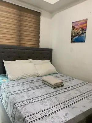 a bedroom with a large bed with a blanket on it at Sea Residence in Manila