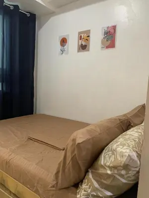 a bed in a bedroom with pictures on the wall at Ballentos staycation in Manila