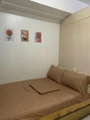 a bed in a room with pictures on the wall at Ballentos staycation in Manila