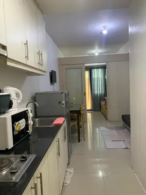 a kitchen with white cabinets and a counter top at Ballentos staycation in Manila