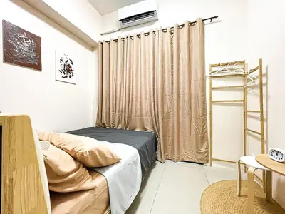 a small room with a bed and a curtain at Rosemary Shore 2 Residences 1BR in Manila