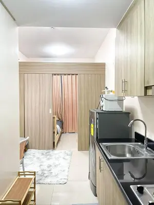 a kitchen with a sink and a living room at Rosemary Shore 2 Residences 1BR in Manila