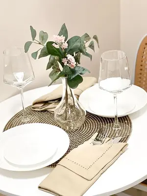 a table with plates and glasses and a vase with flowers at Rosemary Shore 2 Residences 1BR in Manila