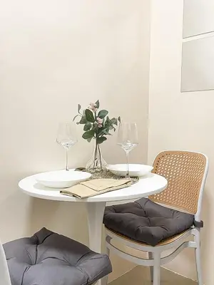 a white table with two glasses and a vase with flowers at Rosemary Shore 2 Residences 1BR in Manila
