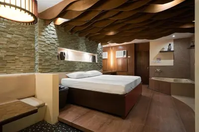 a bedroom with a bed and a sink and a tub at Victoria Court Suites - Pasig in Manila
