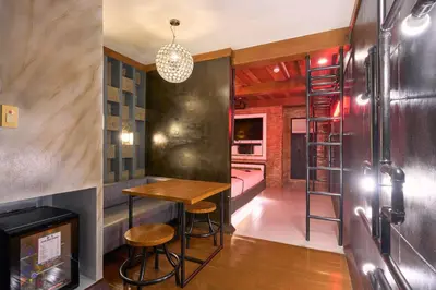 a bar with a ladder and a room with a bed at Victoria Court Suites - Pasig in Manila