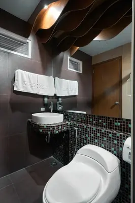a bathroom with a toilet and a sink at Victoria Court Suites - Pasig in Manila