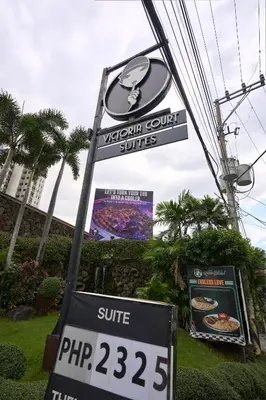 a sign for a viki court suite with a sign for a pizza at Victoria Court Suites - Pasig in Manila