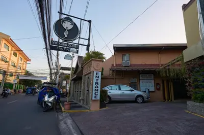 a sign for a restaurant with a car parked on the street at Victoria Court Las Pinas in Manila