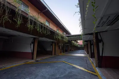 an empty alleyway between two buildings with a bridge at Victoria Court Las Pinas in Manila