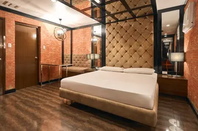 a bedroom with a bed and a brick wall at Victoria Court Las Pinas in Manila