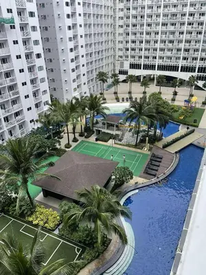 an aerial view of a tennis court with palm trees and buildings at AJ Staycation at Shore 1 Residences Tower D in Manila