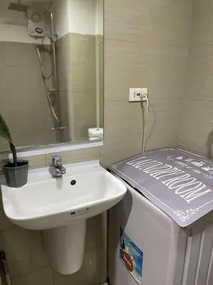 a bathroom with a sink and a toilet and a mirror at AJ Staycation at Shore 1 Residences Tower D in Manila
