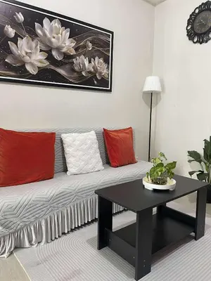 a living room with a couch with red and white pillows at AJ Staycation at Shore 1 Residences Tower D in Manila