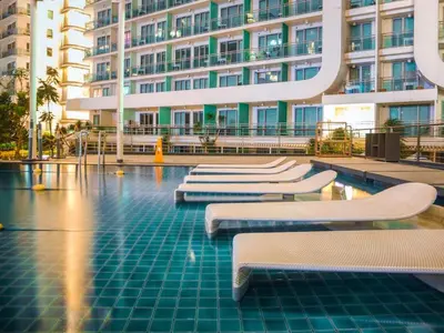 a pool with white benches in front of a building at Casa Rhea in Manila