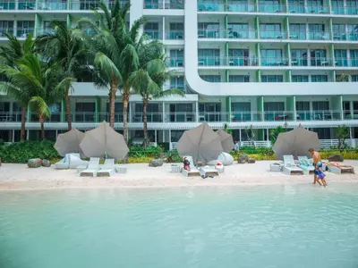 a beach with chairs and umbrellas in front of a building at Casa Rhea in Manila