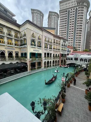 a river in the middle of a building with boats in it at Cozy Staycation Venice with Balcony Mckinley near Bgc in Manila