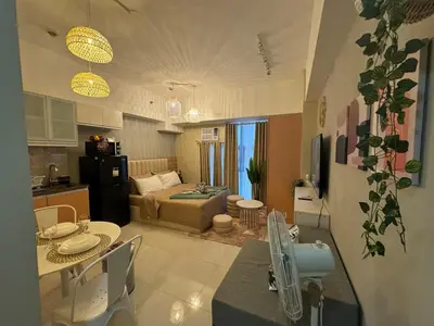 a kitchen and a living room with a table and chairs at Staycation near Venice Mall mckinley taguig in Manila