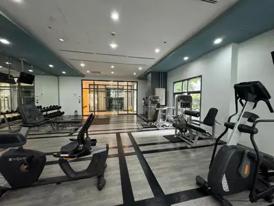 a gym with treadmills and ellipticals in a room at Staycation near Venice Mall mckinley taguig in Manila