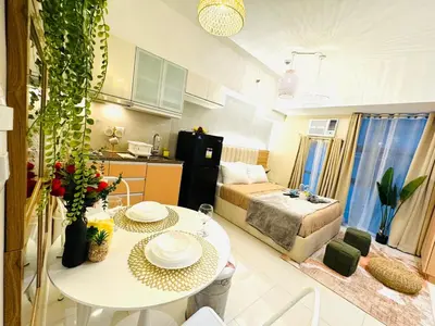 a kitchen and a living room with a table in a room at Staycation near Venice Mall mckinley taguig in Manila