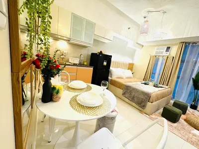 a kitchen and living room with a table in a room at Staycation near Venice Mall mckinley taguig in Manila
