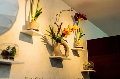 a wall with three shelves with flowers on them at Chic Romantic Getaway Makati Studio One BR Two BR Swim Gym 300 MB in Manila