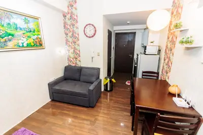 a living room with a chair and a dining room table at Chic Romantic Getaway Makati Studio One BR Two BR Swim Gym 300 MB in Manila