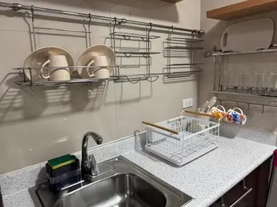 a kitchen sink with a dish drying rack above it at Grand Riviera Suites 1201 Near US Embassy and St Luke's Medical Center Extension Clinic SLEC by Prime Stay in Manila