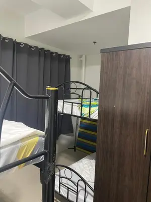 a room with two bunk beds and a wooden cabinet at Moa view with big balcony 558 in Manila