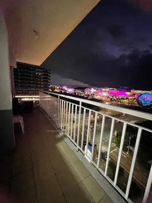 a balcony with a view of a city at night at Moa view with big balcony 558 in Manila