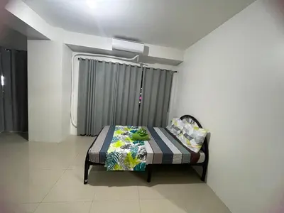 a bed sitting in a room with a window at Moa view with big balcony 558 in Manila