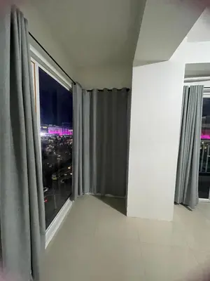 a room with a window with a view of a city at Moa view with big balcony 558 in Manila