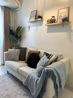 a living room with a couch with pillows on it at Casa Alia at Coast - near MOA, US Embassy, PICC, WTC in Manila