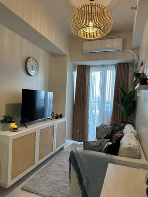 a living room with a tv and a couch at Casa Alia at Coast - near MOA, US Embassy, PICC, WTC in Manila