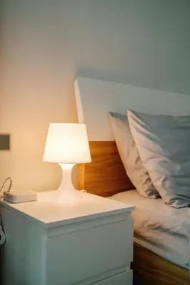 a white lamp on a table next to a bed at Cozy 2-Bedroom at South of Market SOMA BGC near SM Aura, Market! Market! & Bonifacio High Street in Manila