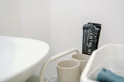 a black toothbrush sitting next to three cups at Cozy 2-Bedroom at South of Market SOMA BGC near SM Aura, Market! Market! & Bonifacio High Street in Manila